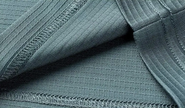 Close-up of the reverse side and interior hemline of the Bermuda Grey silk polo, showing the neat overlock stitching and breathable weave — From Borcelleclothes.