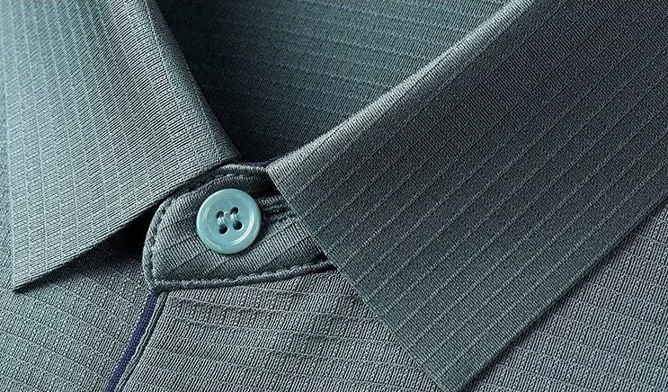 Close-up of the tailored knit collar and unbuttoned placket on the Bermuda Grey silk polo, showcasing the concealed contrast trim and fine tonal stitching — From Borcelleclothes.