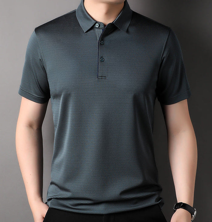 Front view of a male model wearing the Fiord blue-grey 100% Mulberry silk polo with a hand in his trouser pocket, highlighting the relaxed fit and natural drape — From Borcelleclothes.