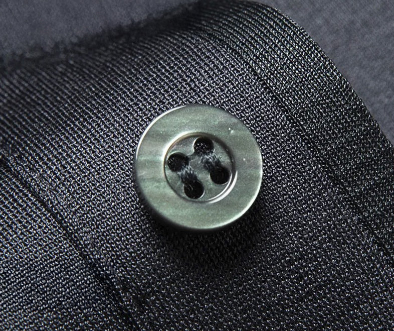 Placket detail on Tender Night silk polo with mother-of-pearl buttons and fine stitch rhythm across the matte-gloss fabric. From Borcelleclothes.