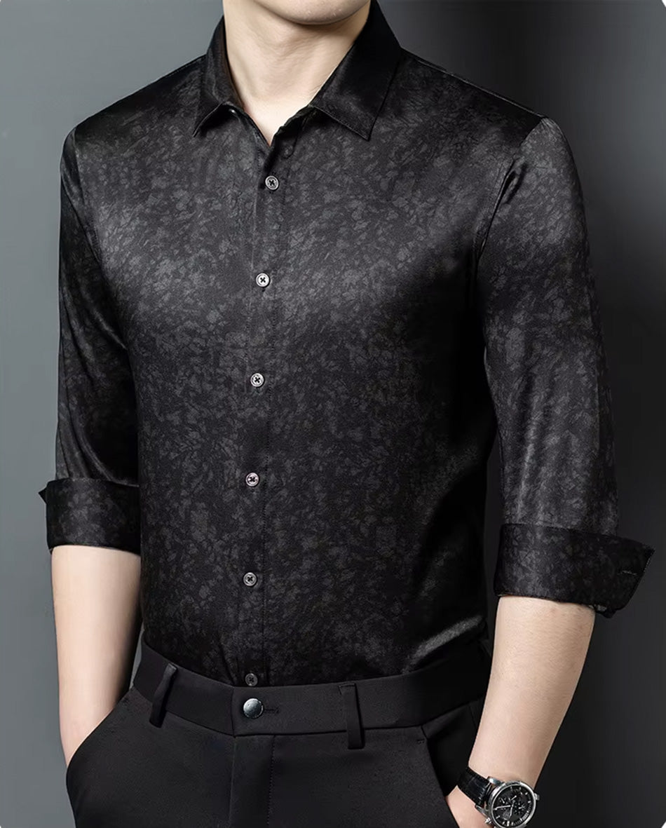 A man capturing a commanding stance in the black Noctis Labyrinthus Mulberry silk shirt, his hands resting in his trousers pockets — From Borcelleclothes.