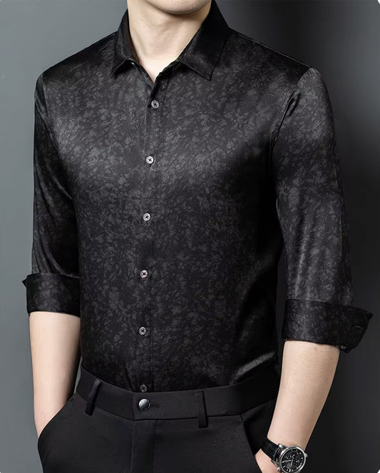 A man capturing a commanding stance in the black Noctis Labyrinthus Mulberry silk shirt, his hands resting in his trousers pockets — From Borcelleclothes.