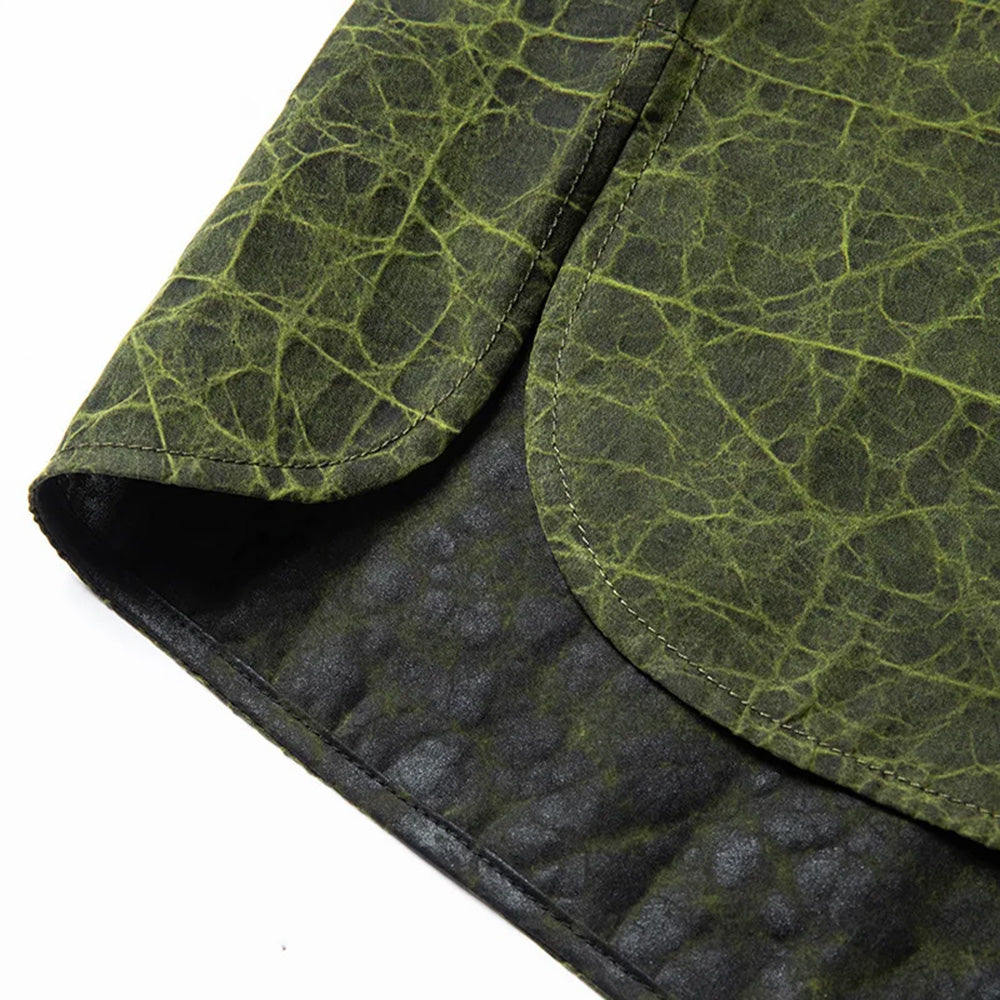 A close-up view of the rounded side slit at the bottom hem of the shirt-jacket on the Chartreuse Glow face — From Borcelleclothes.