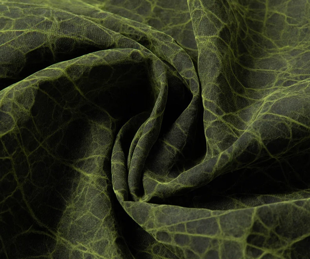 Detailed close-up of folded Xiangyunsha Mulberry silk fabric, highlighting the natural mud-cracked texture and vibrant Chartreuse Glow mineral coloration — From Borcelleclothes.