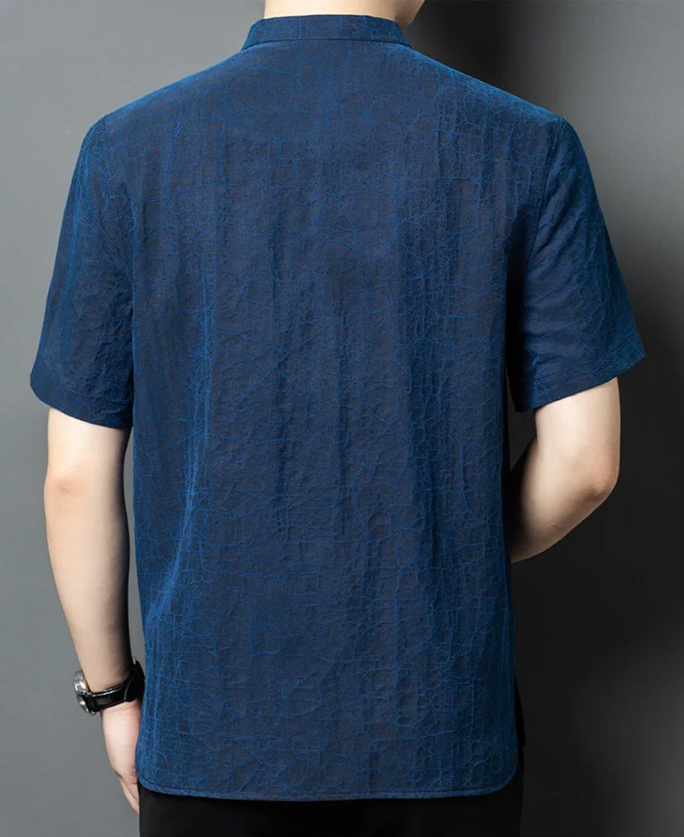 Full back view of a man wearing the reversible jacket on the Neon Indigo face, displaying the deep blue undertones cutting through the dark mineral texture — From Borcelleclothes.