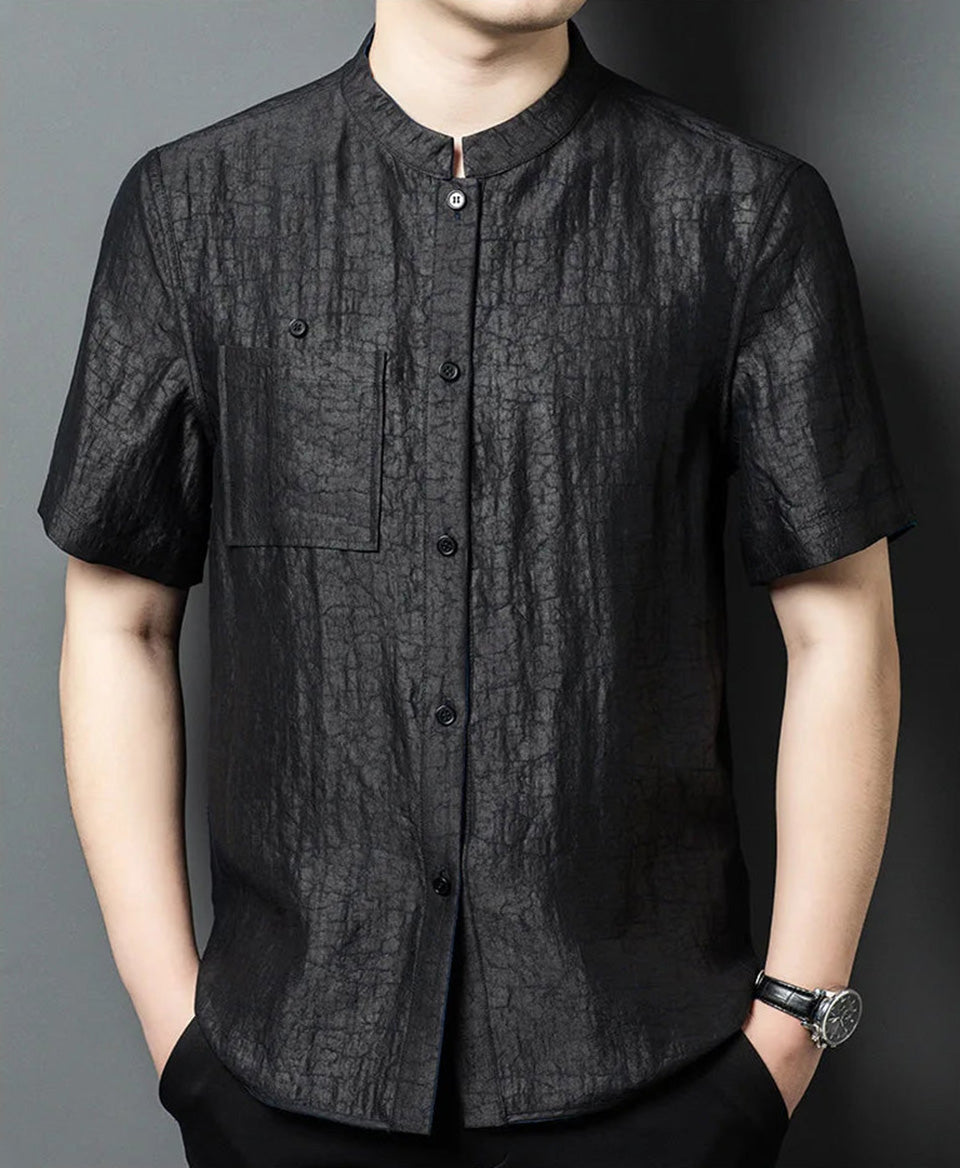 Front view of a man posing with hands in pockets, wearing the structured reversible jacket on its matte-black face — From Borcelleclothes.