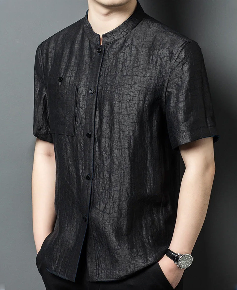Side-angle view of a man modeling the reversible silk shirt-jacket on the solid black graphite side — From Borcelleclothes.