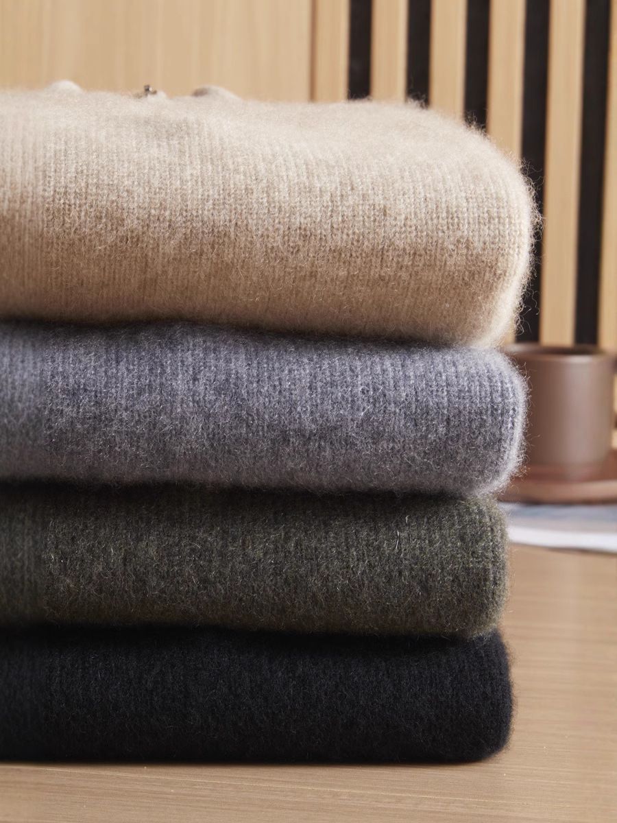Neatly folded stack of men’s ribbed Arbas cashmere sweaters displaying all available natural shades — From Borcelleclothes.