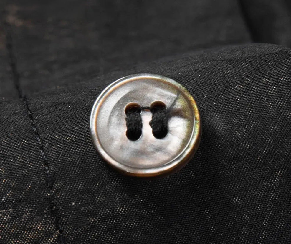Button detail on Men's Xiangyunsha silk shirt in Rutilated Graphite color, featuring a unique handmade needle-like amber texture — From Borcelleclothes.