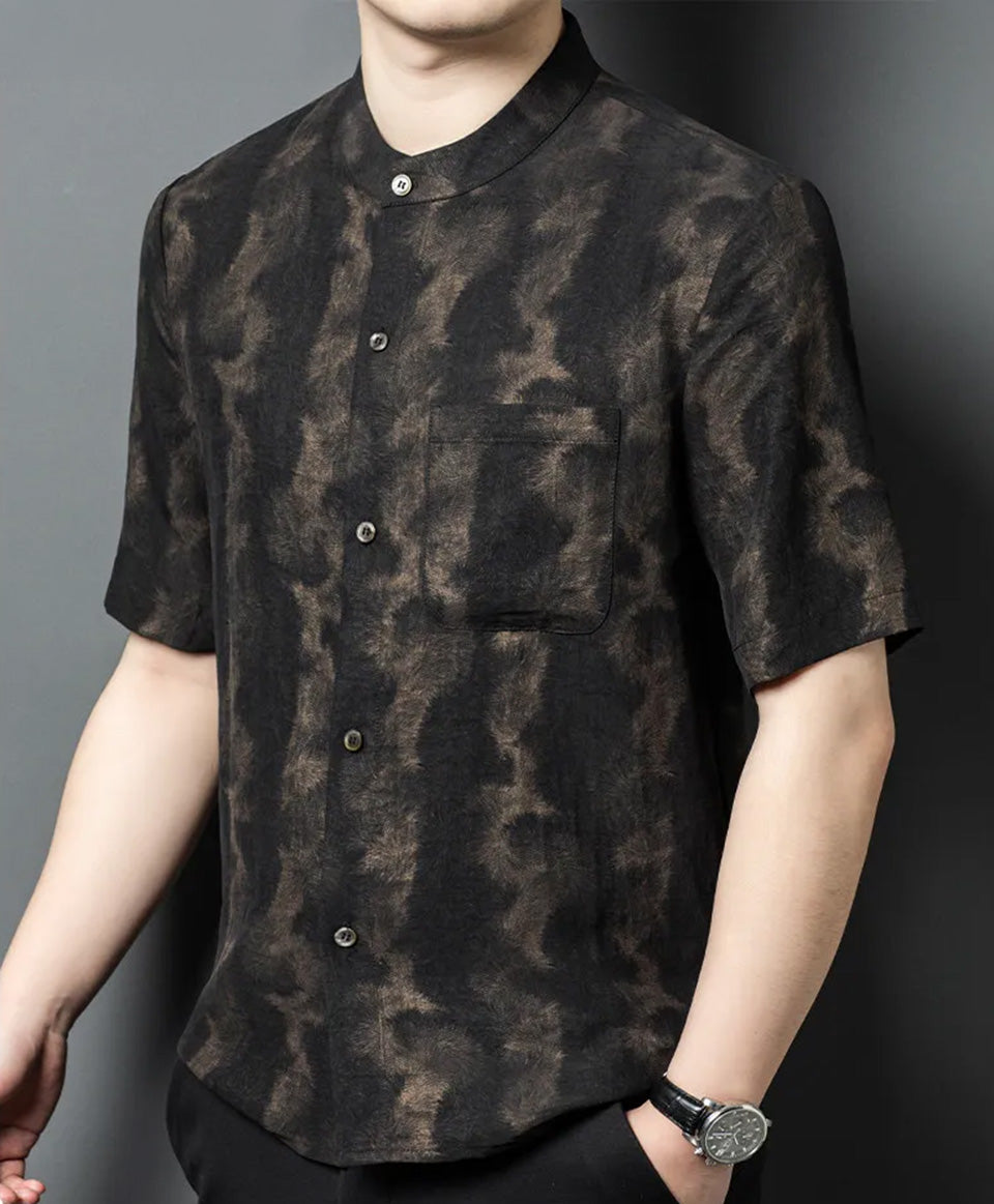 Model turned slightly to the side with one hand in trousers pocket, wearing Men's Xiangyunsha silk shirt in Rutilated Graphite color — From Borcelleclothes.