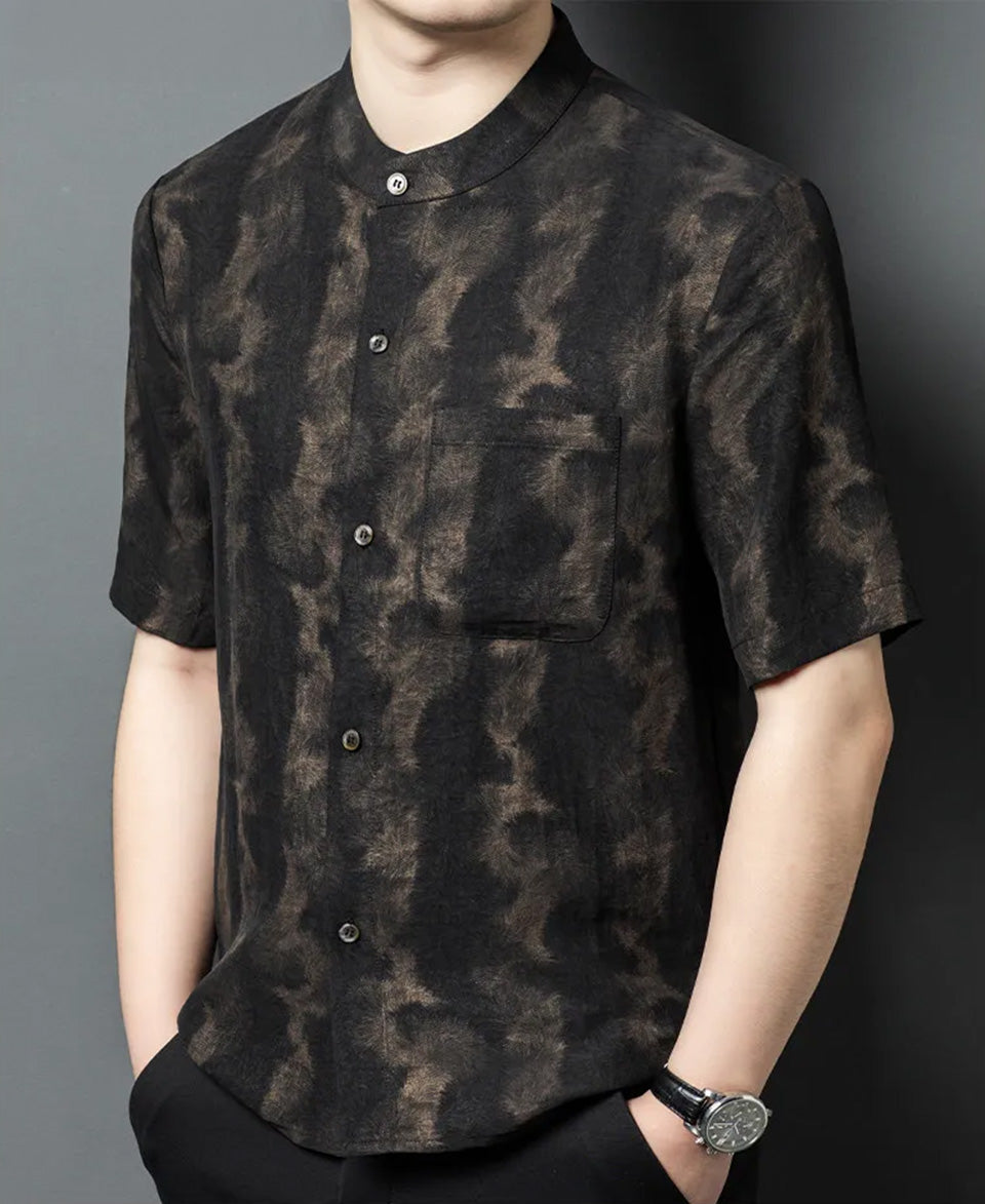 Model turned slightly to the side wearing Men's Xiangyunsha silk shirt in Rutilated Graphite color, featuring a band collar and a unique handmade amber pattern — From Borcelleclothes.