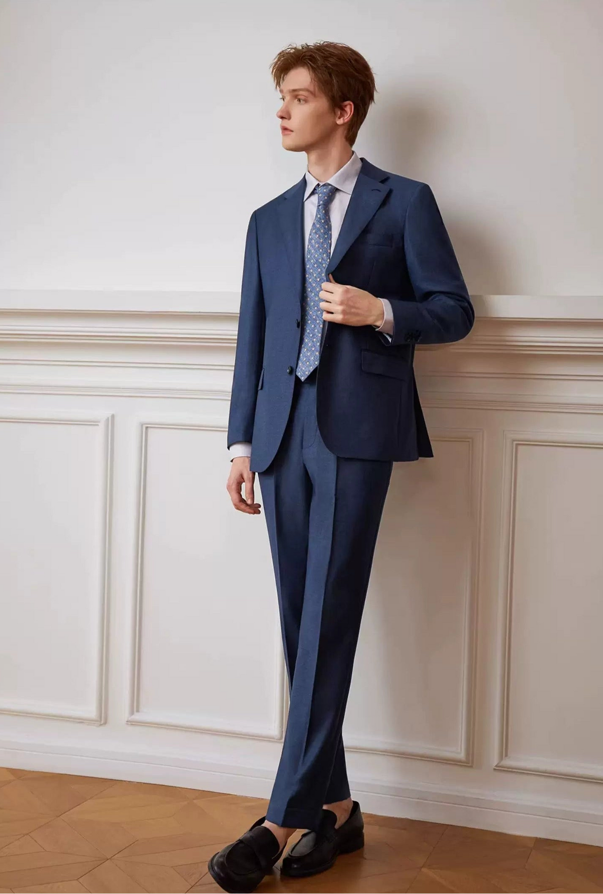 Model gently holding the front lapel edge of the unfastened Salt Wave melange wool blazer — From Borcelleclothes.