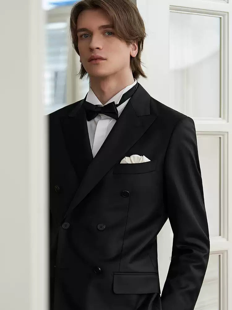 Portrait of the model looking directly into the camera, framed by broad peak lapels and a classic six-on-two button stance — From Borcelleclothes.