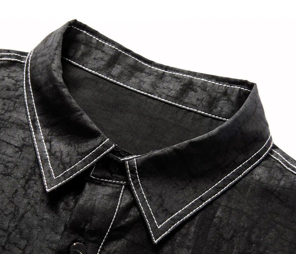 Detailed view of the crisp pointed collar and three-button placket, framed by precise, rugged white contrast topstitching on black silk — From Borcelleclothes.