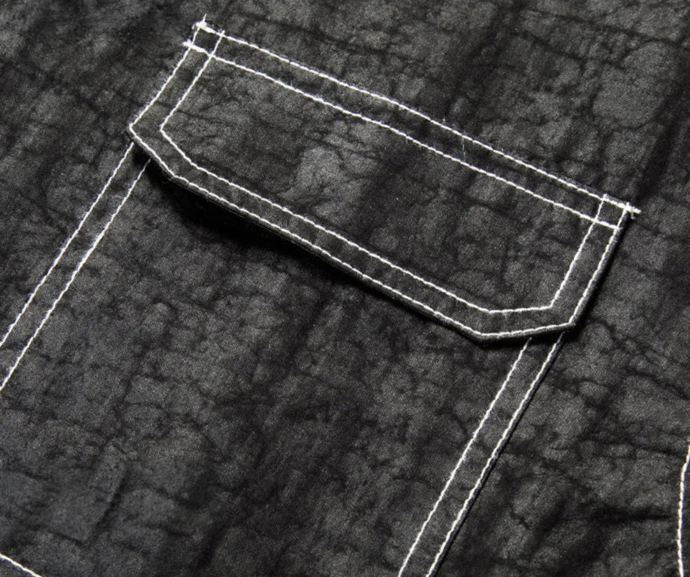 Close-up of the left chest patch pocket with a flap, highlighted by the architectural white contrast topstitching against the matte-graphite silk — From Borcelleclothes.