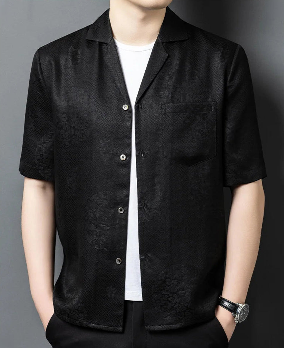 A relaxed, unbuttoned men's shirt-jacket in Beyond Mistletoe, styled with hands in trousers pockets to showcase the fluid, architectural drape of the premium Suzhou silk. — From Borcelleclothes.