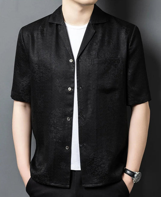 A relaxed, unbuttoned men's shirt-jacket in Beyond Mistletoe, styled with hands in trousers pockets to showcase the fluid, architectural drape of the premium Suzhou silk. — From Borcelleclothes.