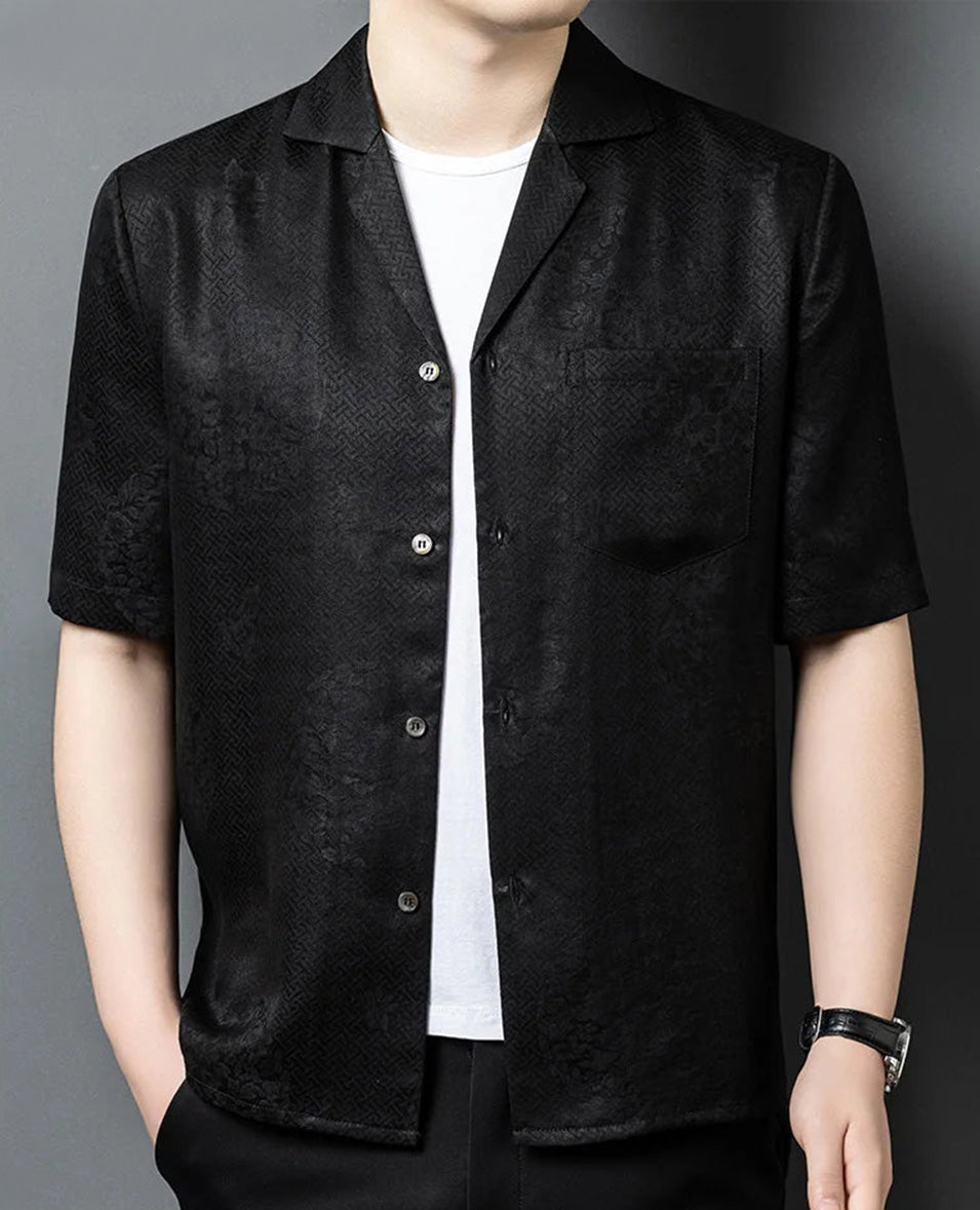 Side view of a male model wearing the unfastened Beyond Mistletoe shirt-jacket with one hand in his trousers pocket, demonstrating the movement and casual elegance of the silk. — From Borcelleclothes.
