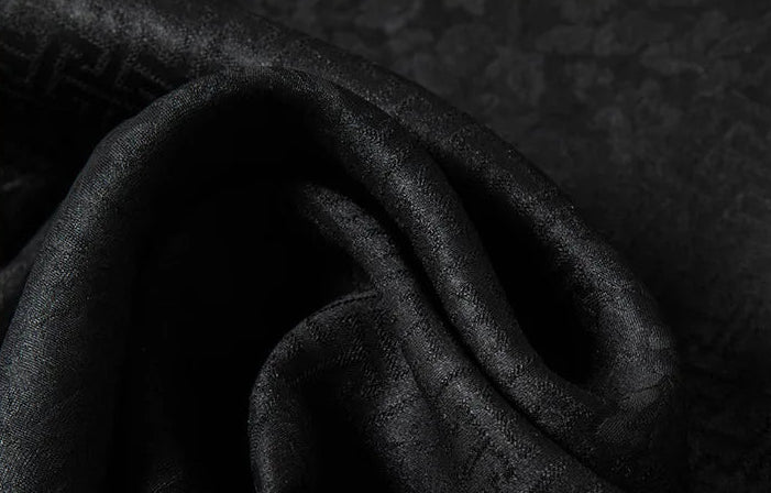 A close-up of the triple-weave Suzhou Mulberry silk jacquard in Beyond Mistletoe, capturing the elusive geometric meander pattern and its subtly raised, wave-folded texture. — From Borcelleclothes.