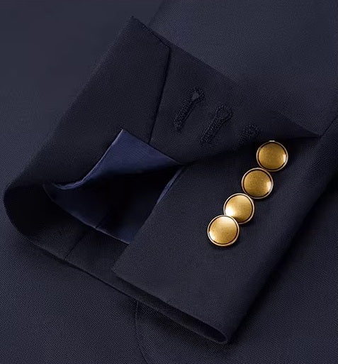 The unfastened sleeve placket on the blazer of the Borcelleclothes Men's VBC Navy Blue Wool Suit with Brass Accents, featuring decorative brass buttons.