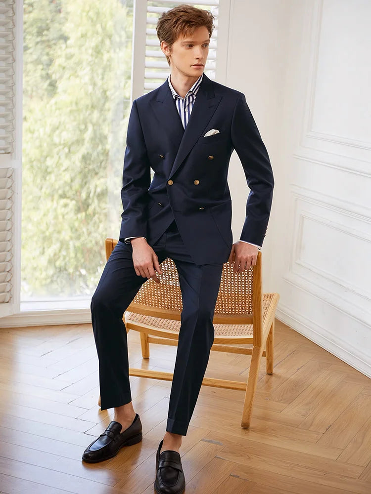 Model seated in a chair, dressed in the Borcelleclothes Men's VBC Navy Blue Wool Suit with Brass Accents, showcasing the relaxed yet commanding elegance of the suit.