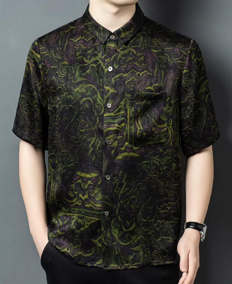 A man wearing the premium Xiangyunsha silk shirt with a chartreuse foliage motif, posing with one hand in his trousers pocket — From Borcelleclothes.