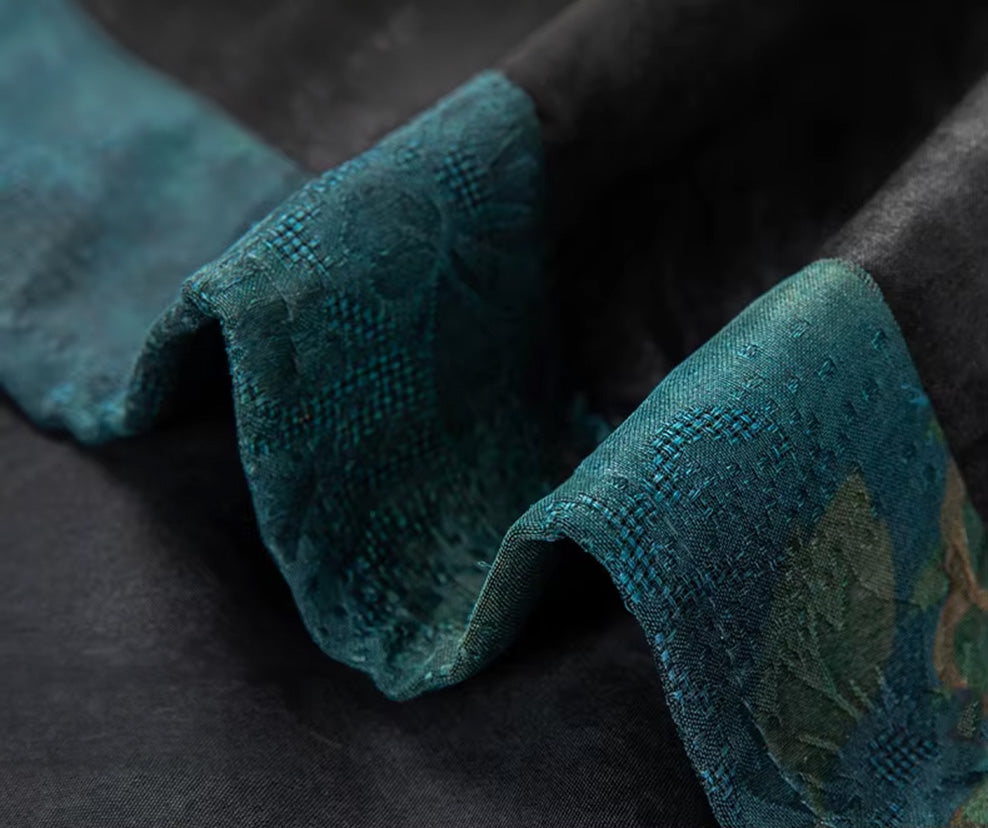 Detailed view of the asymmetrical malachite green jacquard insert along the bottom hem of the graphite silk shirt-jacket — From Borcelleclothes.