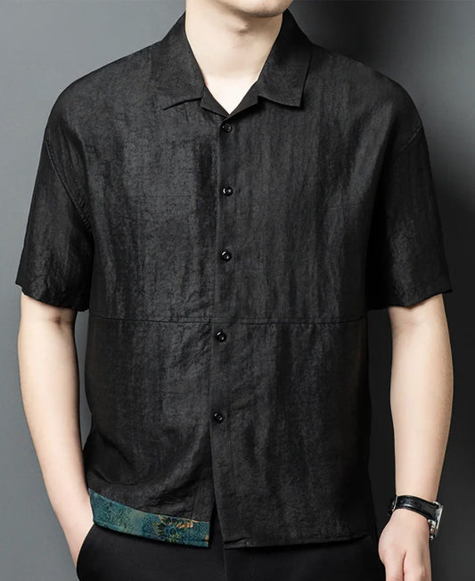 A man standing with his hand in his trousers pocket, showcasing the fit and texture of the Parchment Graphite Xiangyunsha silk shirt-jacket — From Borcelleclothes.