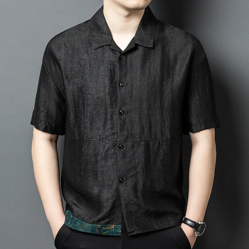 Men's relaxed short-sleeve shirt-jacket in matte Parchment Graphite Xiangyunsha silk, featuring a Cuban collar and horizontal front mid-seam. — From Borcelleclothes.