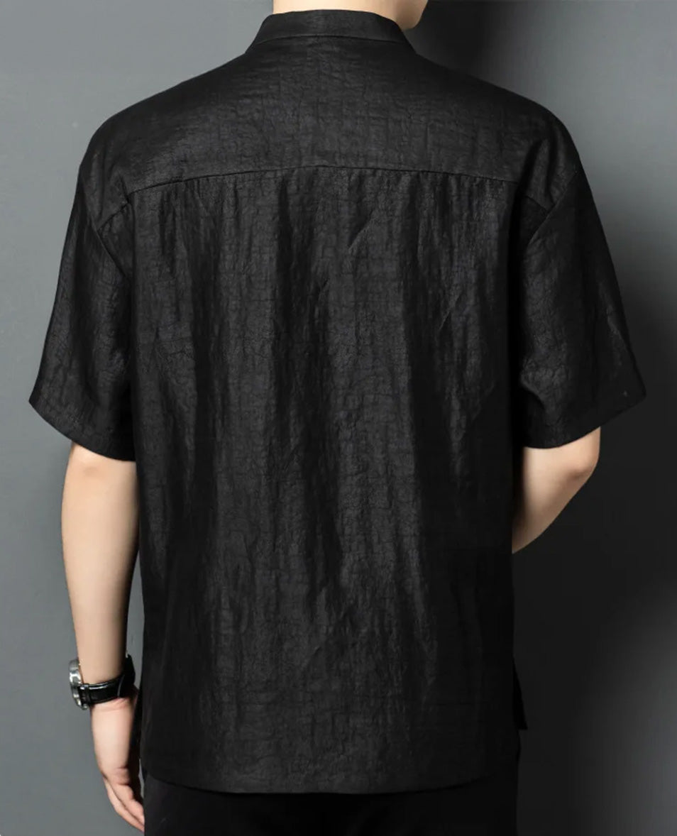 Back view of a model in a structural black Mulberry silk overshirt, highlighting the clean shoulder yoke construction. From Borcelleclothes.