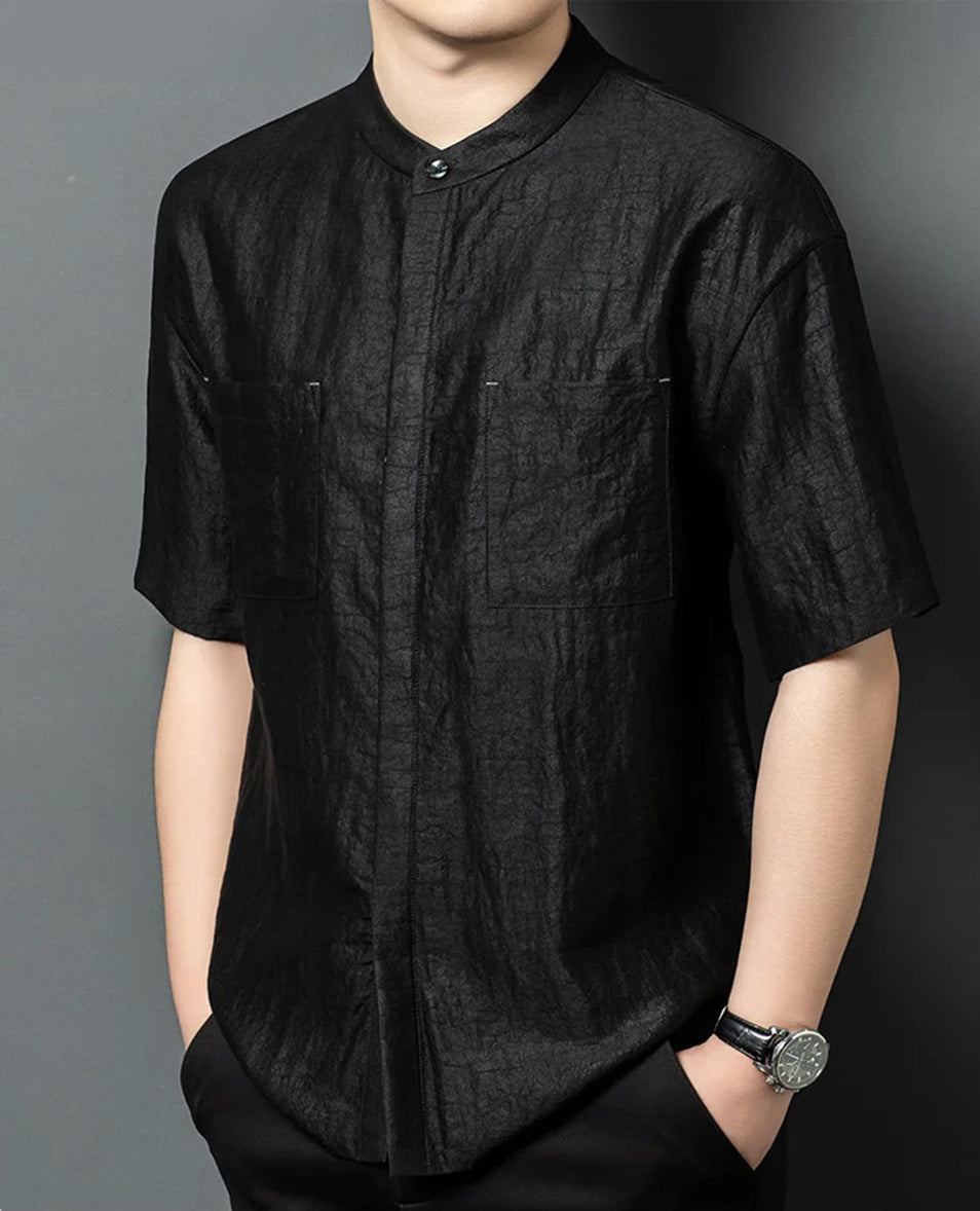 A model turned slightly to the side, showcasing the relaxed fit and straight silhouette of the mineral-dyed silk shirt. From Borcelleclothes.
