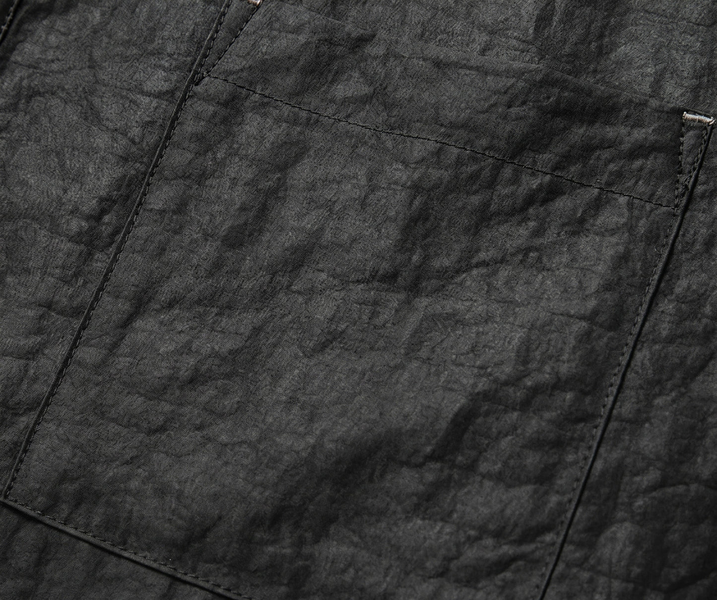 Close-up of a chest patch pocket on a black silk shirt, accented with precise silver-threaded bartack stitching. From Borcelleclothes.