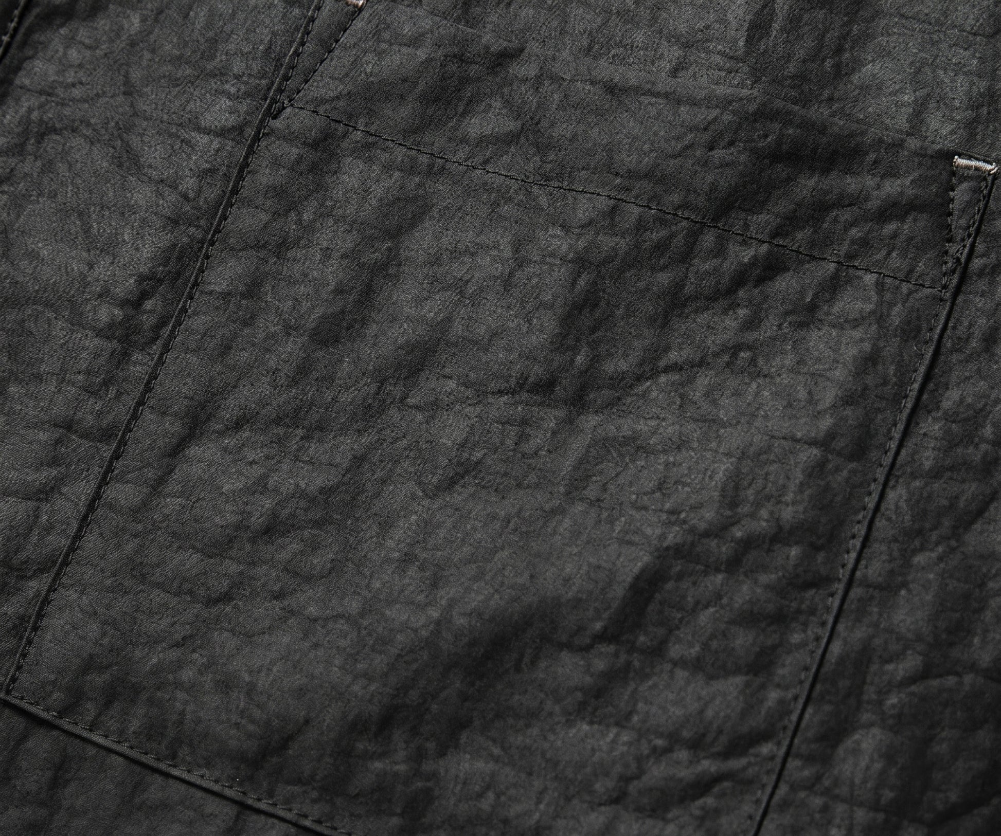 Close-up of a chest patch pocket on a black silk shirt, accented with precise silver-threaded bartack stitching. From Borcelleclothes.