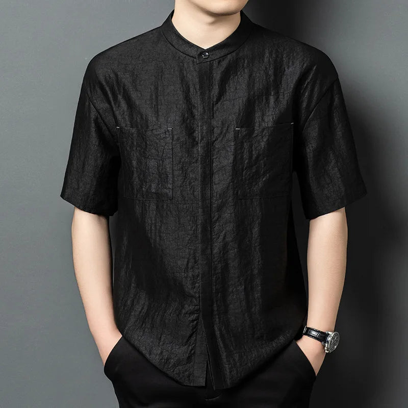 Men's minimalist shirt crafted from rare, heritage Guangdong Gambiered silk in Coolness of a River Stone color. Features a strict band collar, concealed placket, patch pockets, and clean side slits. — From Borcelleclothes.