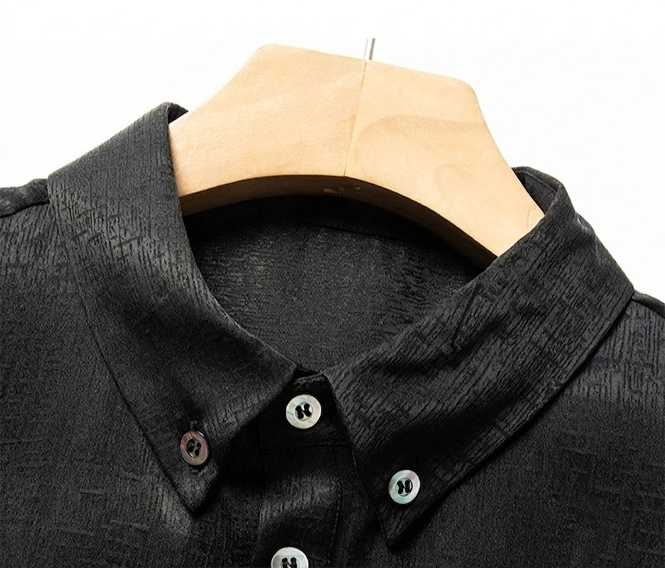 Detailed shot of the button-down collar on the heavyweight graphite-black silk shirt, secured with genuine mother-of-pearl buttons against the dense, matte-finished fabric - From Borcelleclothes.