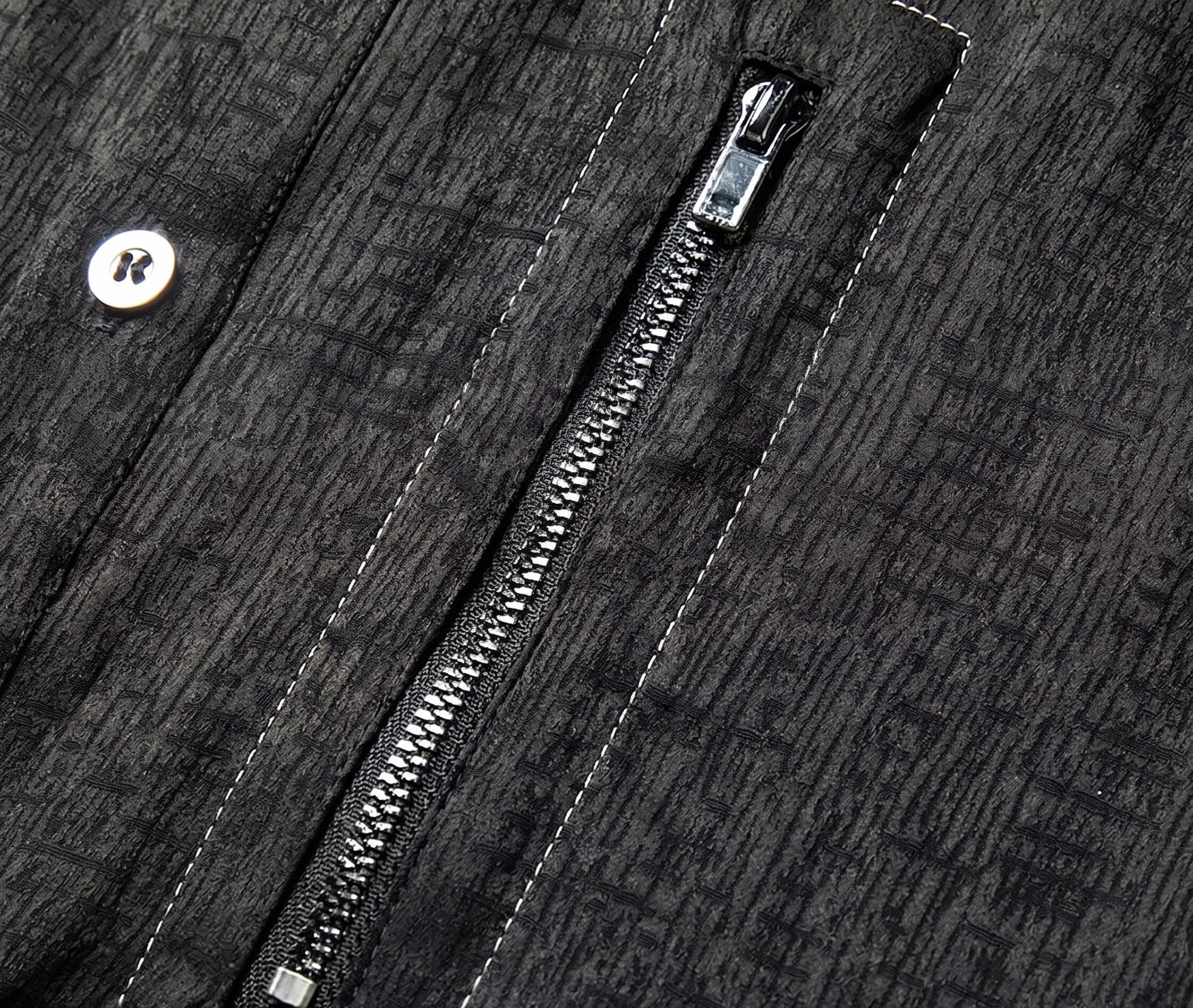 Extreme close-up of the left chest pocket with a functional metal zipper closure, framed by precise contrast topstitching on the elephant-skin textured silk jacquard - From Borcelleclothes.