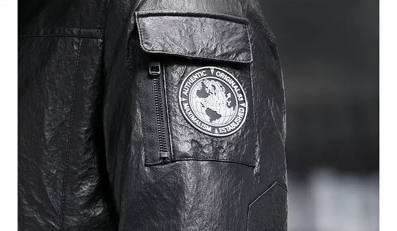 View of the sleeve pocket with flap, zipper, and tonal rubber badge — From Borcelleclothes.