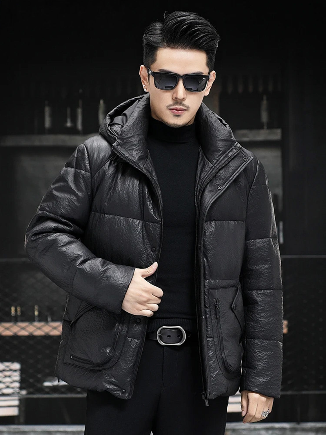 Model holding the front edge of the unzipped Onyx jacket, revealing inner texture — From Borcelleclothes.