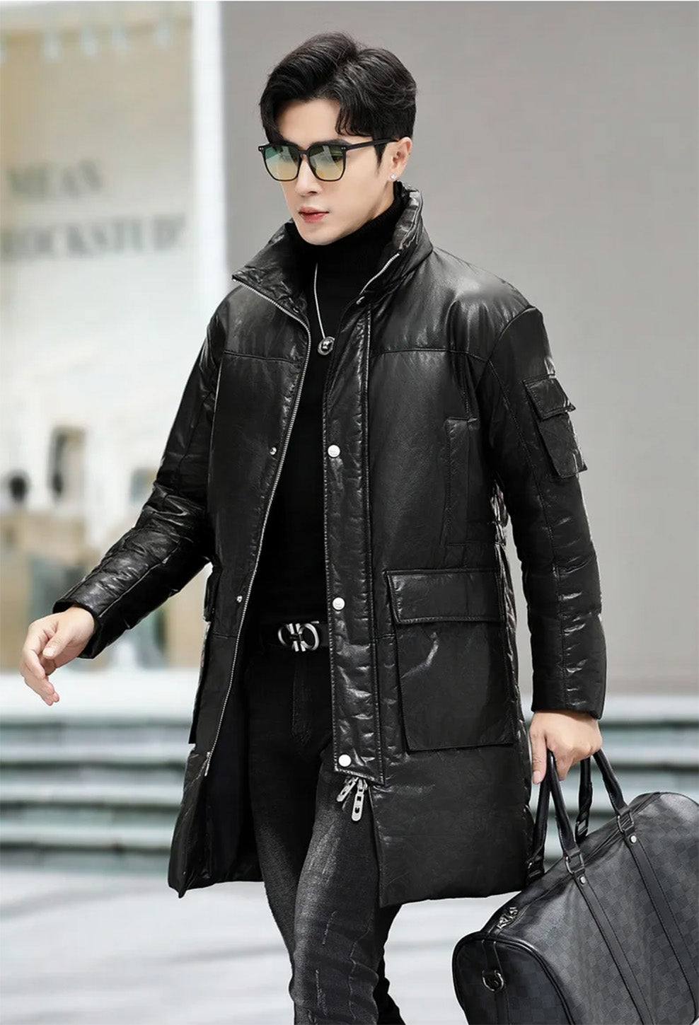 Model holding an oversized bag while wearing the cowhide coat with cargo pockets in Onyx — From Borcelleclothes.