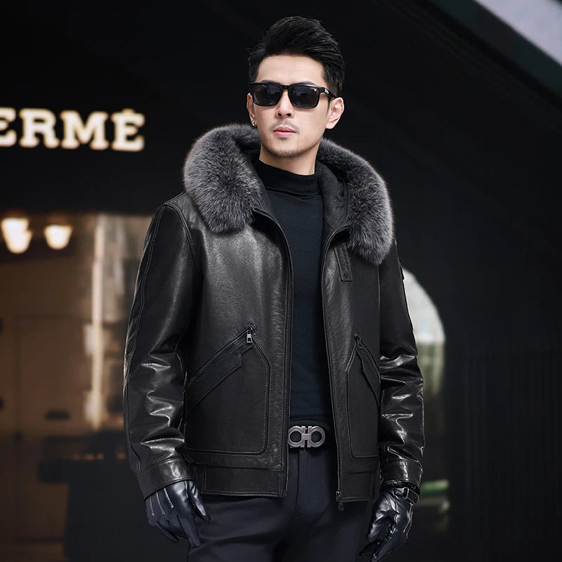 Men’s cowhide leather coat in Onyx with detachable fox fur hood trim, piped curved pockets, badge detail, and snap cuffs. — From Borcelleclothes.
