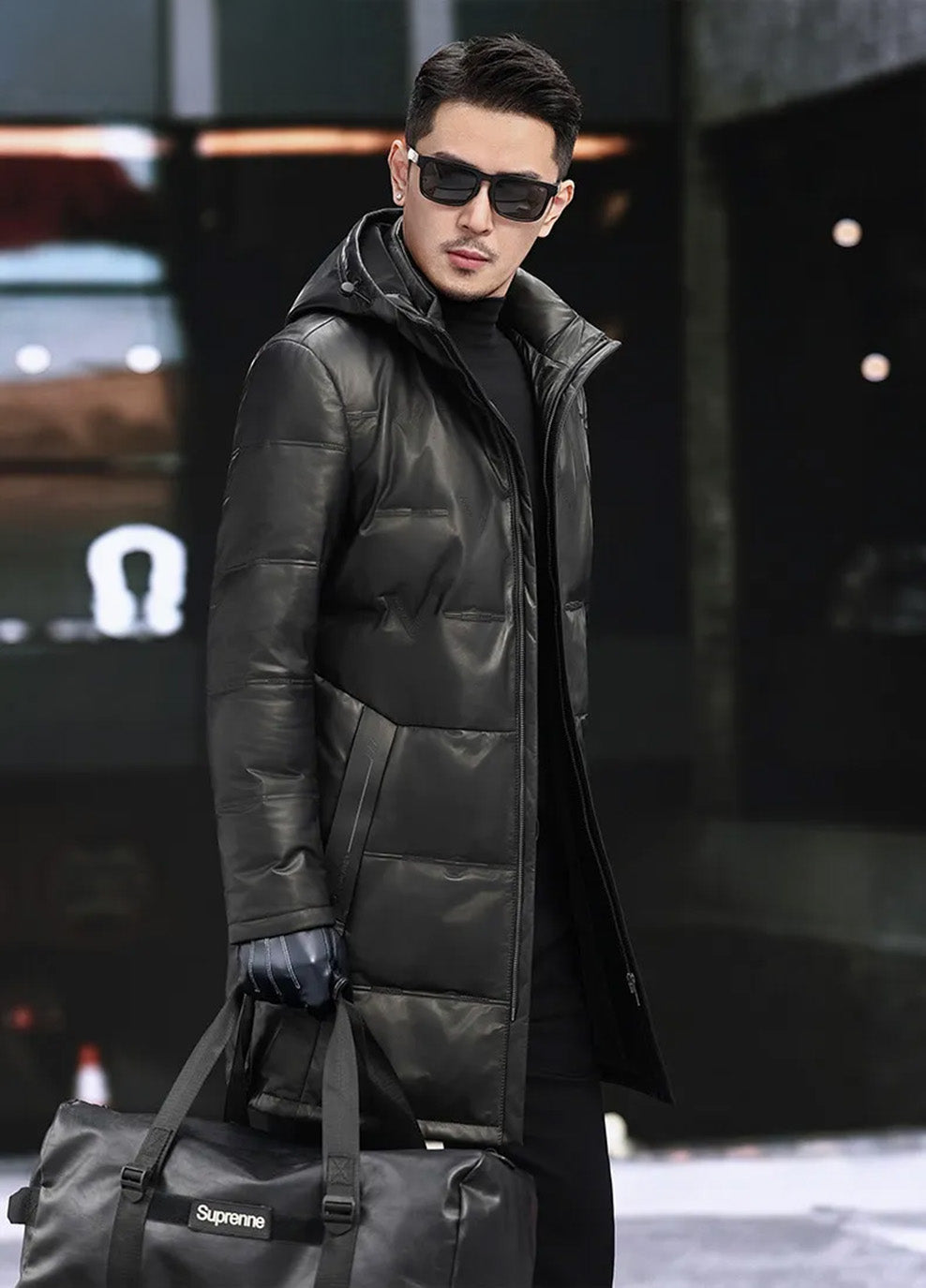 Three-quarter side view of model in Onyx cowhide down coat with sculptural hood and tonal pattern. — From Borcelleclothes.