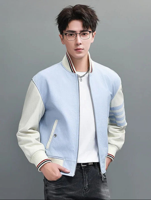 Men’s cowhide leather varsity jacket in pale-blue Link Water with ivory sleeves; model with hands in jeans pockets; black-red rib tipping and hip-length cut. - From Borcelleclothes.
