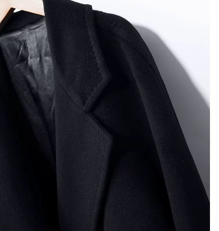 The left upper part of the Men’s Double-Breasted Belted Cashmere Coat in Black Pearl, highlighting the precise lapel tailoring. From Borcelleclothes.