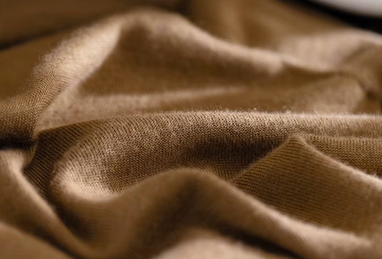 Men's Grade A Cashmere Quarter-Zip Sweater in French Beige, being held to highlight the softness and lightweight luxury of its 100% Alashan Cashmere fabric. From Borcelleclothes.