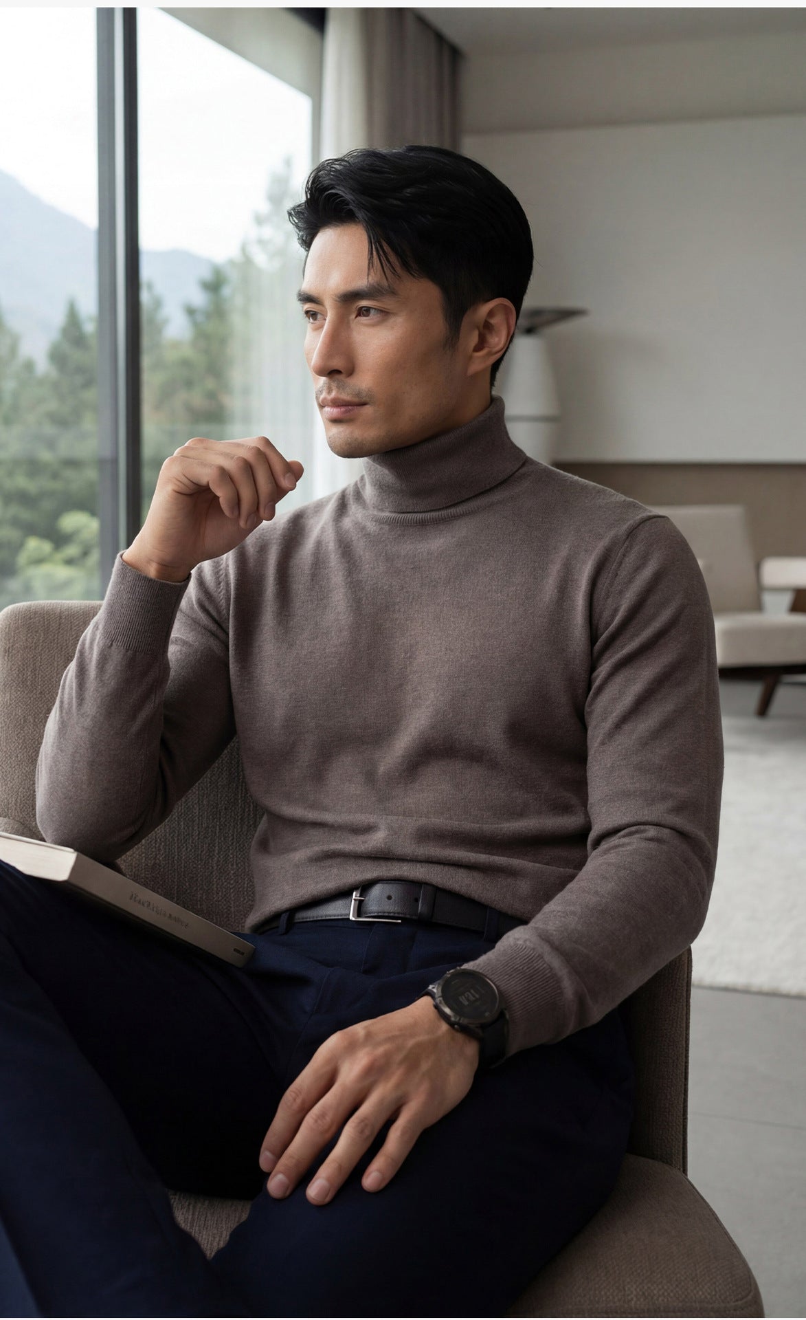 Model looking through the window wearing Men's Regular-fitting cashmere turtleneck in stockinette stitch with 1x1 ribbed neck, cuffs, and hem, in Umber color — From Borcelleclothes.