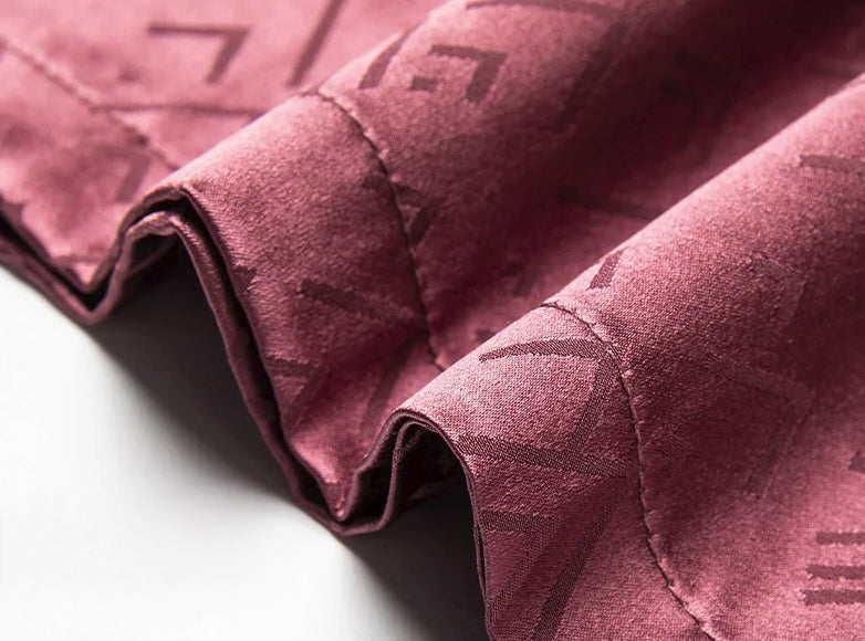 Lower hem of the Coral Tree polo — even and steady, with the jacquard pattern flowing gently to the edge. From Borcelleclothes.