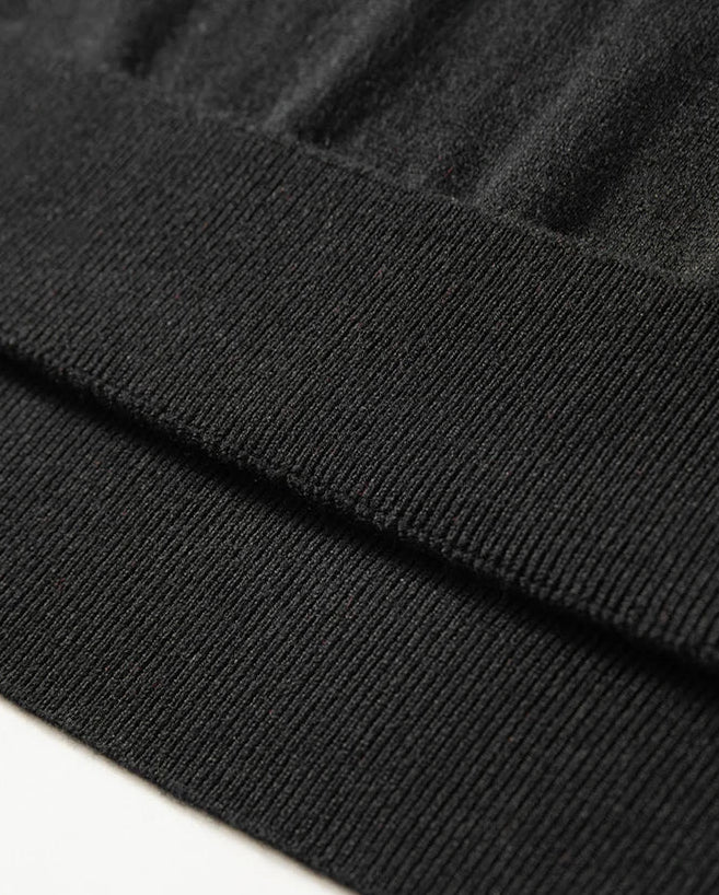 Unfolded ribbed hem of the Men’s knitted silk-cashmere polo shirt in Onyx— featuring a soft drape and wide collar that rests gently on the shoulders. From Borcelleclothes.