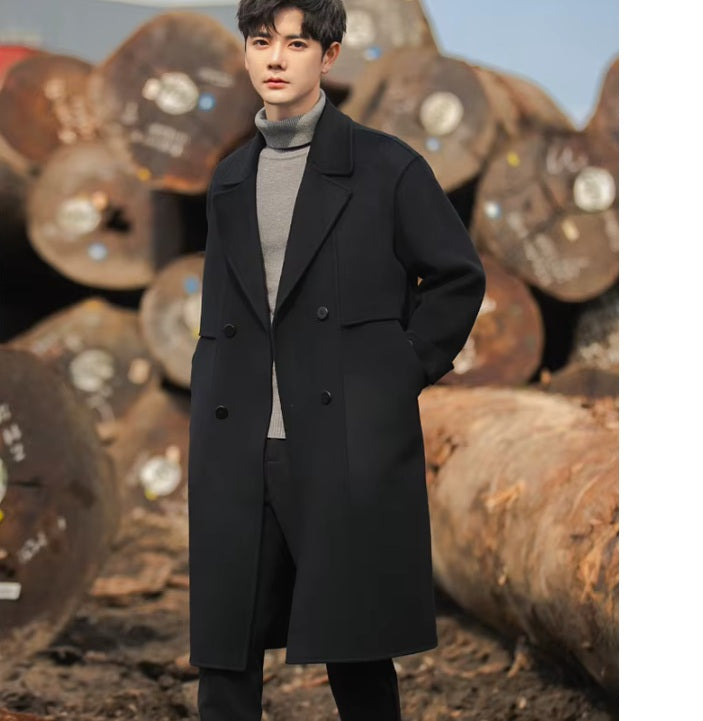 A model wearing the Men's Luxurious Double-Faced Coat in Onyx, slightly turned to showcase the structured double-breasted design and refined architectural silhouette. From Borcelleclothes.