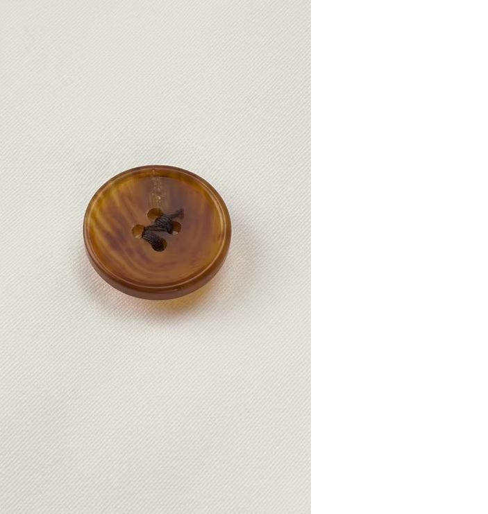 The Men's Luxury Alabaster Suit's horn-brown button, emphasizing its luxurious and refined detail. From Borcelleclothes.