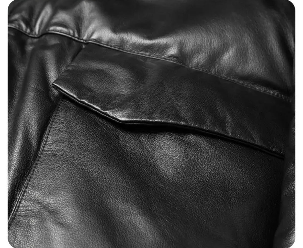 Curved flap detail of extended cargo pocket on cowhide down coat in Onyx — From Borcelleclothes.